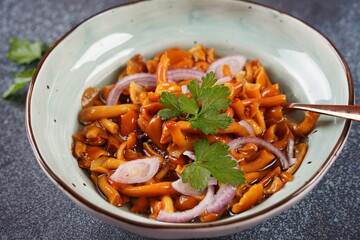 Marinated wild honey fungus Armillaria mellea mushrooms with spices and onions in the bowl