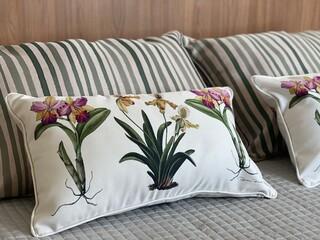 combination of pillows with flower prints and stripes on the bed
