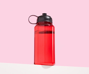 Red sports water shaker. Exercise in a gym.