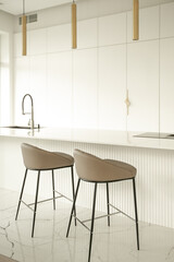 Minimalistic light interior of modern kitchen with island and high chairs