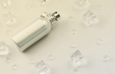 Female perfume silvery bottle, Objective photograph of metallic perfume bottle in ice cubes and...