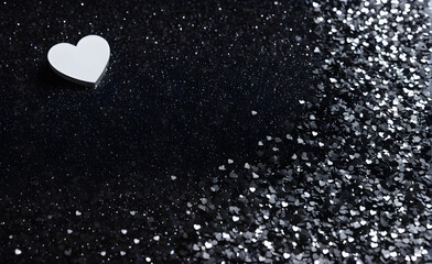 A small white heart on a sparkling black background. Generative AI