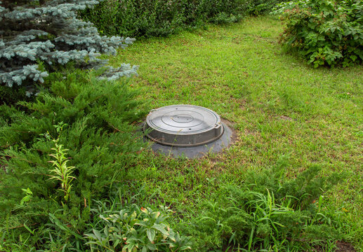Sewer hatch of a cesspool on the site of a rural house.