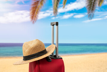 For travel and vacations purposes, a simple modern suitcase in red color at tropical beach with a...