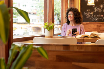 woman in cafe using mobile phone