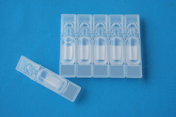 Single use artificial tear lubricant eye drops containers, tubes, isolated on blue background....
