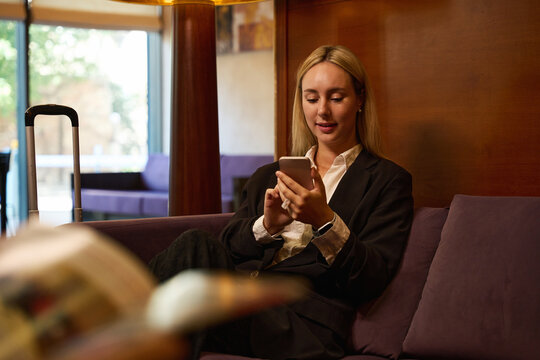 Close up photo of businesswoman sitting with smartphone in hands