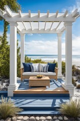 White-washed wood pergola attached to a blue beach cottage over a paved backyard patio with wicker seating and a propane fire table.