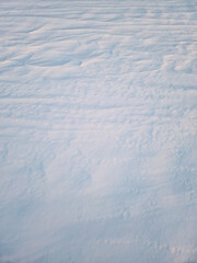 Winter snowdrifts abstract texture of snow shaped by the wind on an empty land in the sunset light