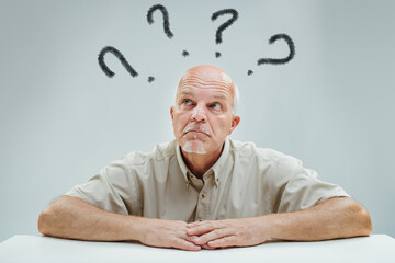 Man's puzzled gaze meets symbolic question marks