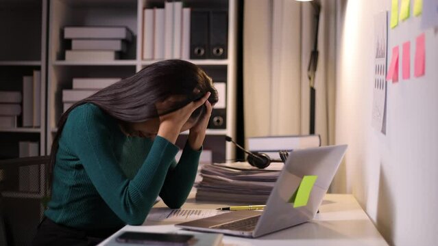 Asian businesswoman working overtime in the office is stressed from overwork and excessive workload.