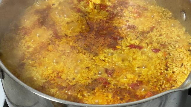 Pilaf during preparation in stainless steel pot on stove top