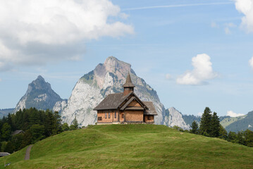 Fototapeta na wymiar chapelle suisse avec montagne en arrière plan à Stoos 