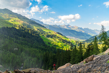 Randonneuse regardant le fond d'un vallée suisse ensoleillée