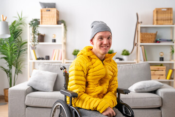 Smiling man with special needs in wheelchair at home