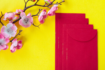 Top view of Chinese New Year red packet and cherry blossom decoration with customizable space for text or wishes. Chinese New Year celebration concept.