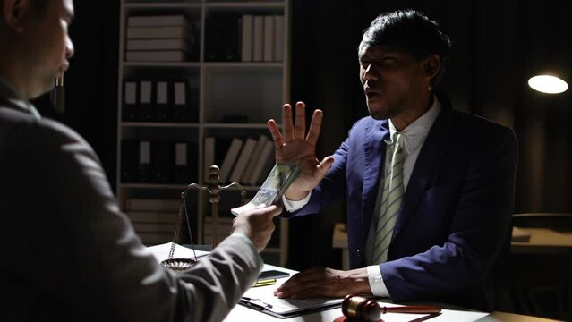 Honest officials or lawyers do not accept and refuse to accept bribes. Anonymous businessman in the dark tries to bribe official or lawyer.