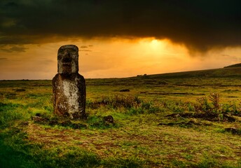 An evocative Moai statue illuminated by the light of dawn on the mysterious Easter Island (Rapa...
