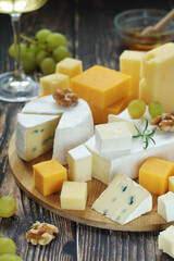 Several types of cheese served with honey and grapes	