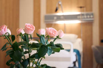 Focus on bouquet of rose flowers in blurred medical room in maternity clinic