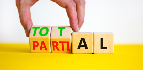 Total or partial symbol. Businessman turns beautiful wooden cubes and changes the word Partial to...