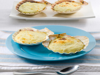  Vieiras al horno con crema de calabacín  sobre plato azul y blanco. Baked scallops with zucchini cream on blue plate