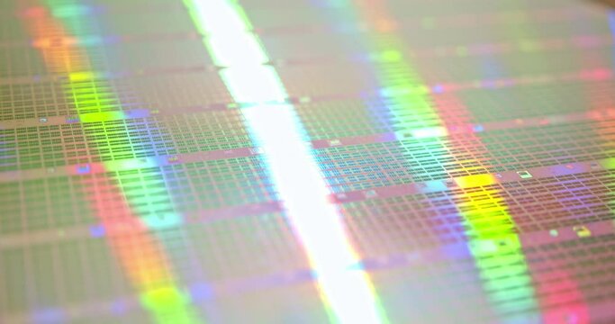A close-up view of a silicon wafer's microprocessor circuit layout. The semiconductors or central processing unit CPU microchips are fabricated from a silicon wafer with patterned layers of materials.