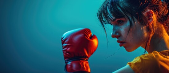 Studio shot of a girl delivering a left jab in kickboxing. - obrazy, fototapety, plakaty