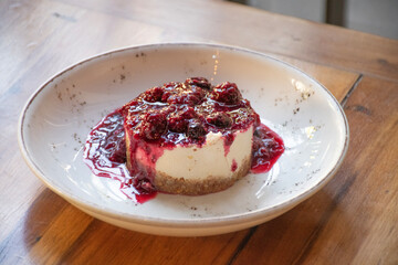 delicious and healthy cheesecake dessert with berry jam on restaurant table