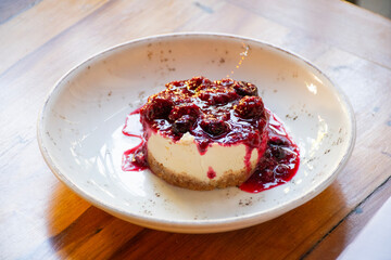 cheese cake dessert with red fruit jam on restaurant table close-up