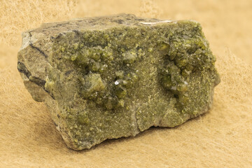 Vibrant Green Epidote Mineral on Matrix Against Light Background