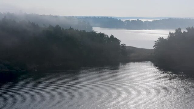 Island formation in peaceful and still sea water on a foggy morning,  Archipelago, Sweden, nearby Stockholm.