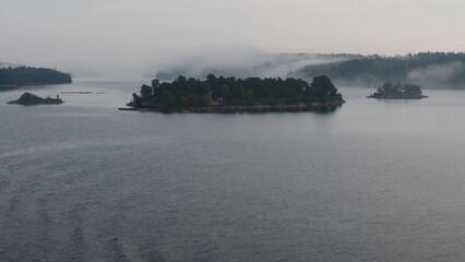 Island formation in peaceful and still sea water on a foggy morning,  Archipelago, Sweden, nearby Stockholm.