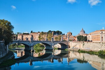 View of the Tiber river, The Sant Angelo Bridge and St. Peters Basilica in the far background, Rome, Italy
