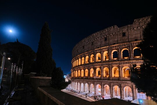 The Colosseum, Architectural wonder of Roman Empire (Colosseo) night view with moonlight, Rome, Italy