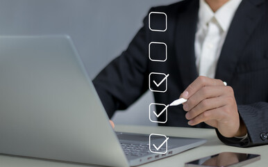 Check list concept.Businessman using laptop with online checklist survey, filling out digital form...