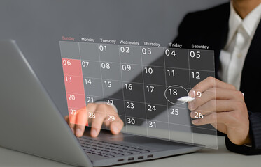 Time management concept. Businessman use laptop to manage time for effective work. Calendar on the virtual screen interface. Highlight appointment reminders and meeting agenda on the calendar..