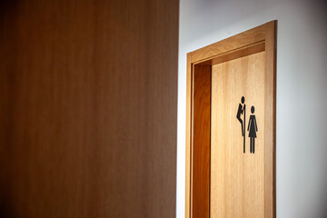 Unique restroom sign at a hotel: a man peeking over the door to the ladies' room. A playful and...
