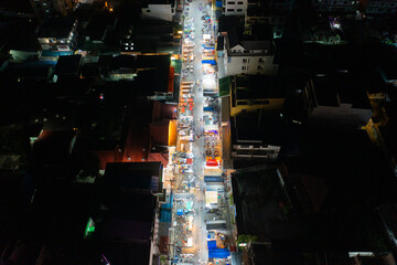 Aerial top view of night temple fair, and night local markets. People walking street, Colorful tents in Bangkok city, Thailand. Retail shops