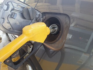 Car at the gas station. fuel pump gun in car tank. Oil industry.