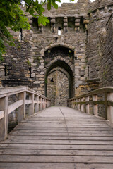 Fototapeta na wymiar Bridge to the gatehouse and portcullis of an old stone medieval castle - Beaumaris Castle, Anglesey North Wales