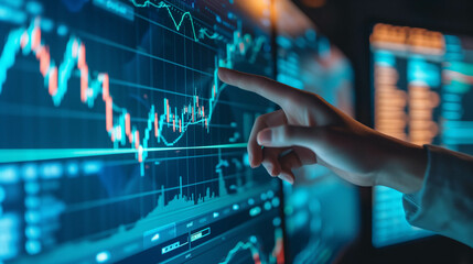 The hand of a businessman or investor pointing at a computer screen, screen with stock market chart analysis or research information for trading and investing