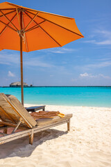 Outdoor tourism landscape. Luxury beach resort closeup beach chairs or beds under umbrellas with...