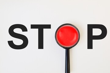 The word STOP with the letter O highlighted in a magnifying glass in red in 3D on white background....