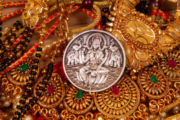 gold jewelery IN wooden Durga, Saraswati or laxmi silver coin isolated on white background ....