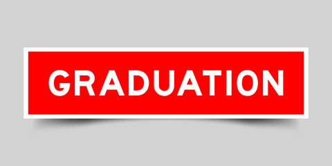 Red color square shape sticker label with word graduation on gray background
