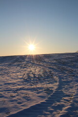 A snowy landscape with a bright sun