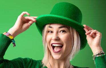 St. Patrick's Day. Joyful girl in a leprechaun hat celebrates St. Patrick's Day in a green sweater.