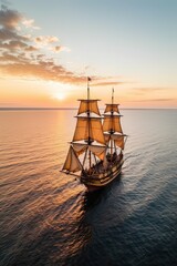 Obraz premium Crimson Tide. Small sailing ship in the open sea at sunset.
