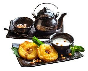 PNG, Asian sweets and tea. Fried pineapple slices in batter, coconut milk sauce, ceramic teapot and a bowl with cane sugar.